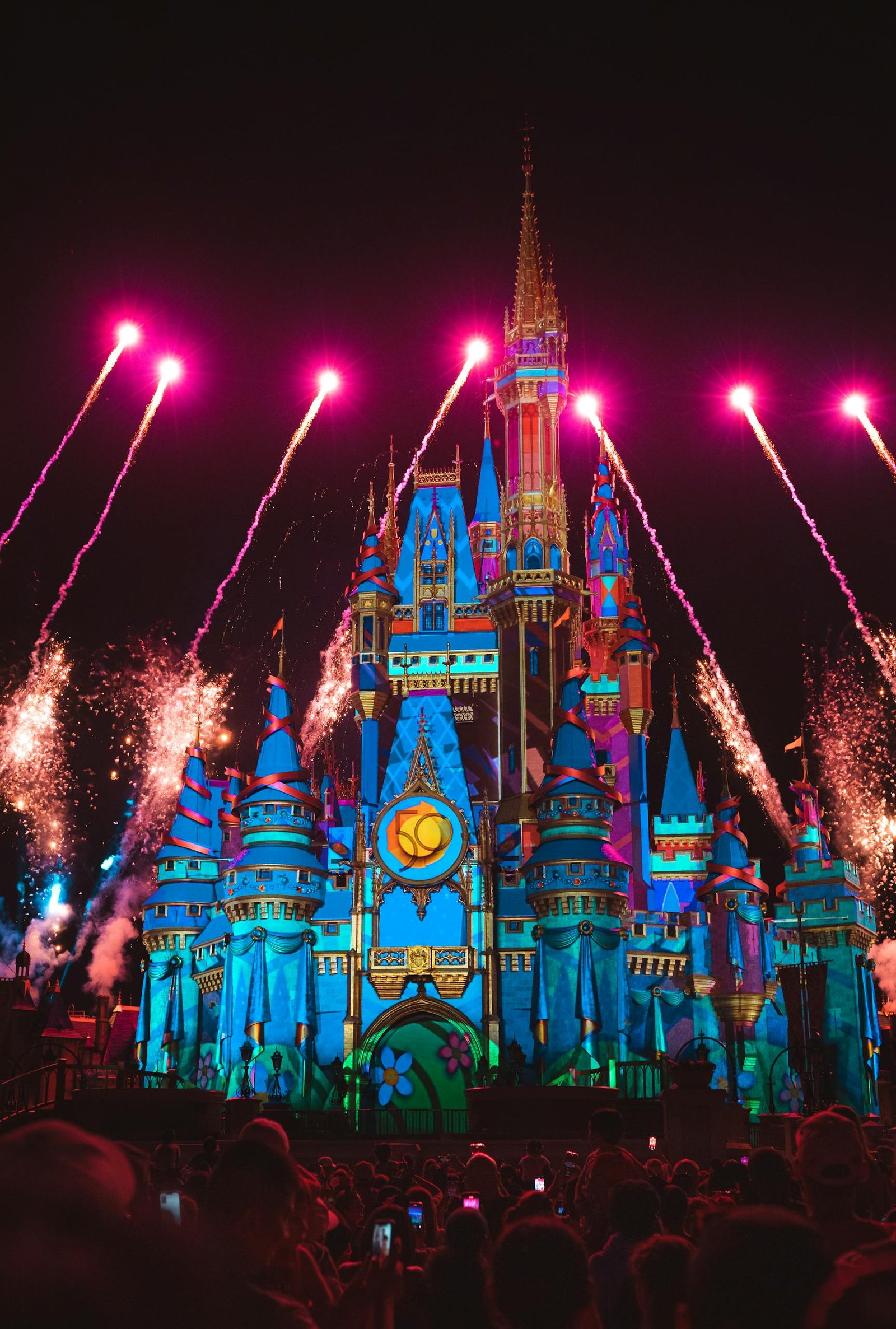 Illuminated castle with vibrant fireworks in Orlando captivates nighttime spectators.
